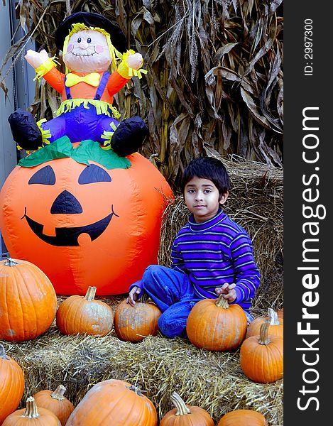 An indian kid having fun with the haloween pumpkins. An indian kid having fun with the haloween pumpkins