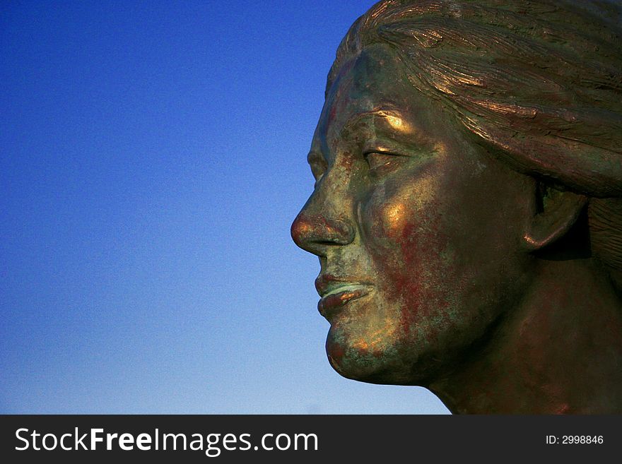A digital image of an iron ladys face with a blue sky background.