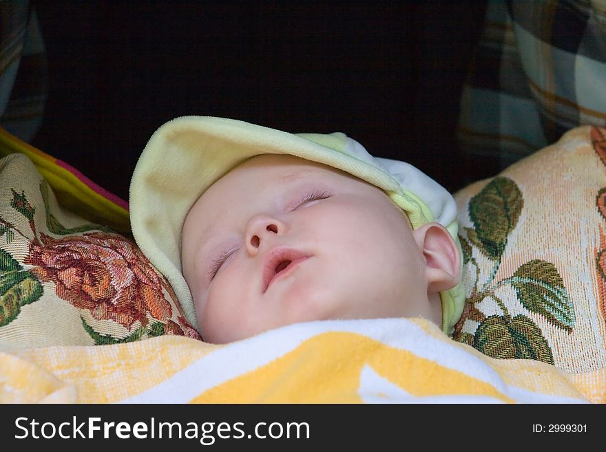 Child sleeping in a walking carriage under a blanket