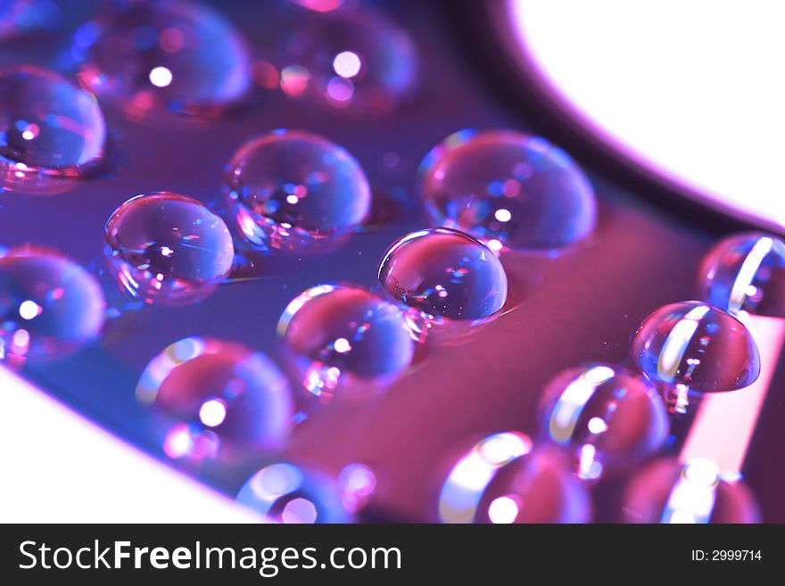 Violet water drop on compact disk for background