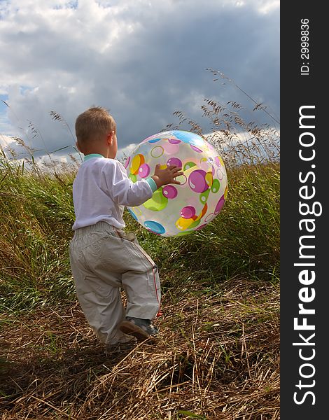 Baby on field with big inflatable ball go back. Baby on field with big inflatable ball go back