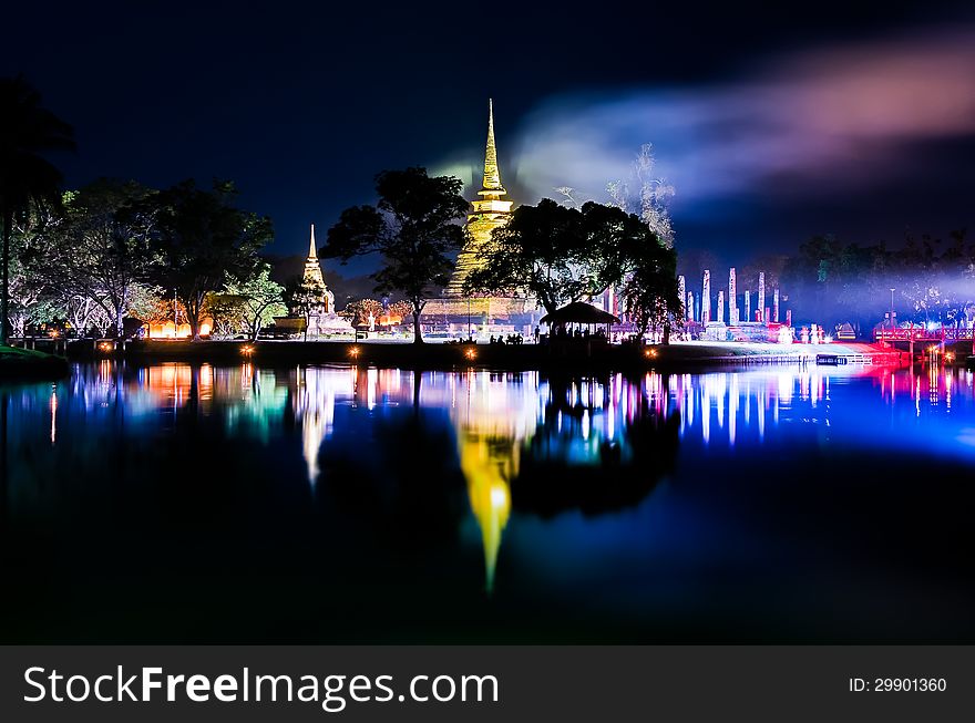 Buddhist colorful temple at night with lake reflection