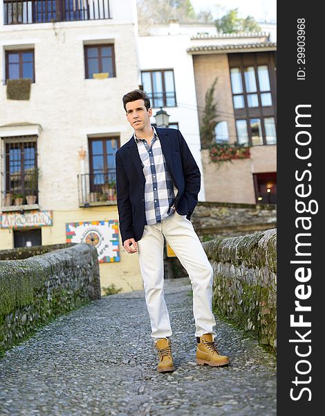 Handsome man with modern hairstyle smiling in urban background