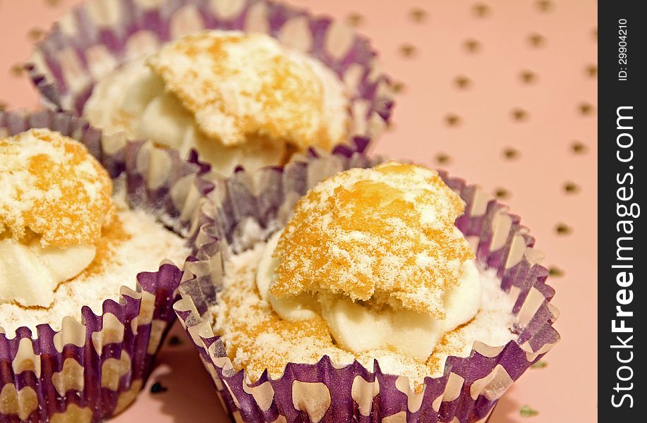 Photo of delicious cupcakes with cream and frosting on pink loveheart background.