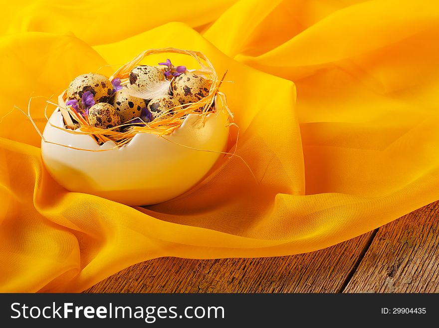 Retro still life with quail eggs and egg cup over yellow scarf background. Retro still life with quail eggs and egg cup over yellow scarf background