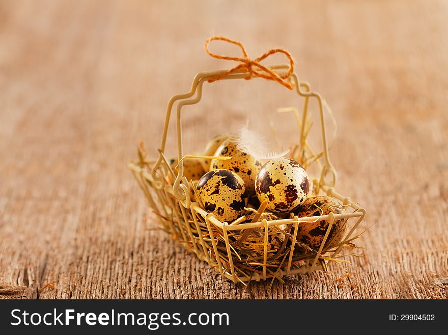 Quail eggs in vintage metal basket on wooden background. Quail eggs in vintage metal basket on wooden background