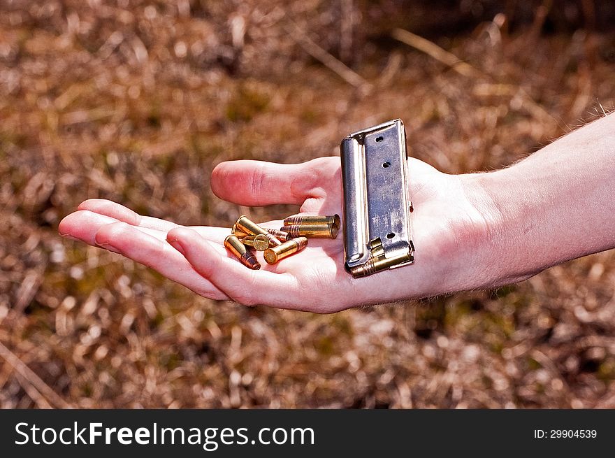 Girl holding bullets and clip while hunting.