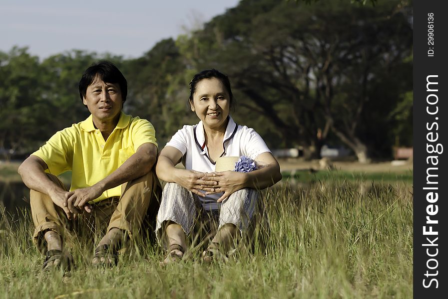 Beautiful Couple Sitting On Ground In Park Relaxing