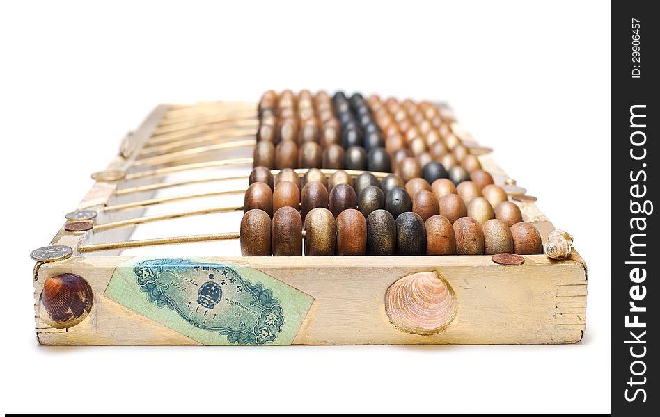 Abstract composition from the old wooden abacus, coins and shells on white background, selectiv focus