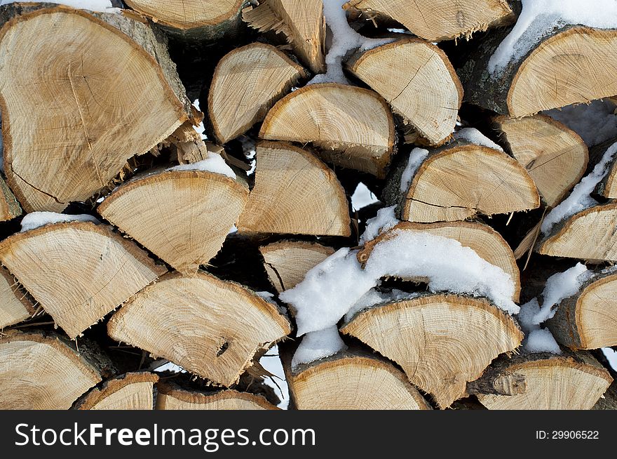 Oak firewood stacked and snowed on in a Minnesota winter