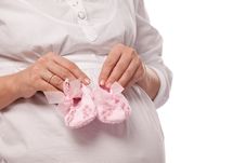 Pregnant Woman Keeping Pink Baby-shoes. Royalty Free Stock Photo