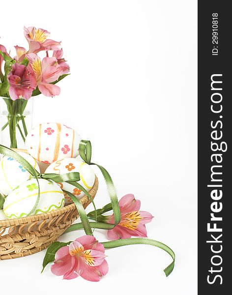 Easter eggs with pink flowers in a wicker basket