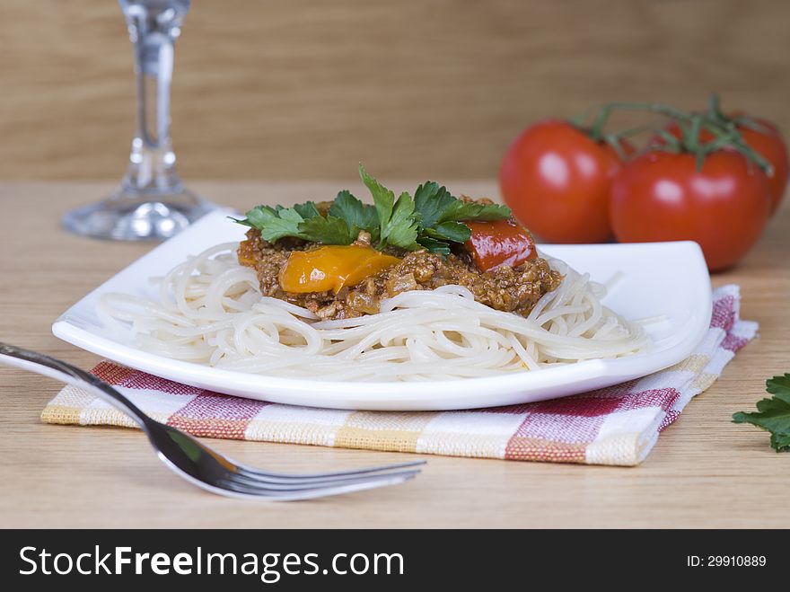 Spaghetti with meat sauce and parsley on a white plate