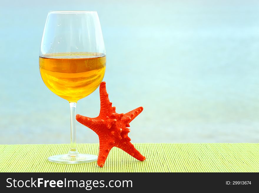 Summer vacation romantic scene with glass of vine and red sea star. Summer vacation romantic scene with glass of vine and red sea star