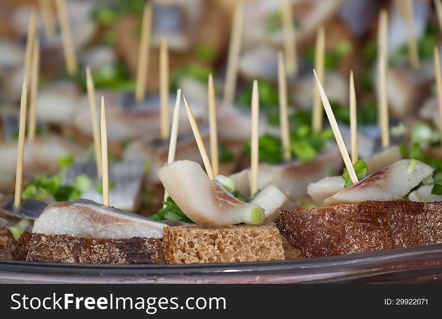 Canape with bread, a herring and green onions. Canape with bread, a herring and green onions