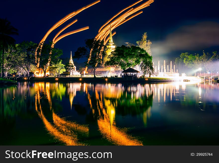 Light lampions at night above buddhist temple in Sukhothai historical park, Thailand