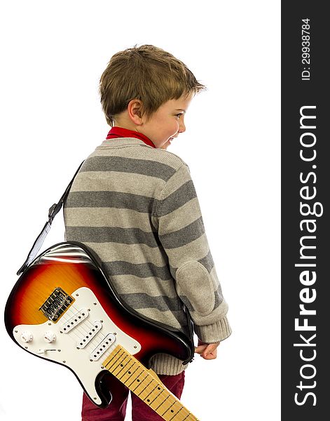 Boy with guitar on his back looking over shoulder. Boy with guitar on his back looking over shoulder.