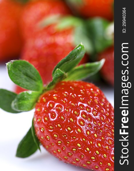 Forefront of a group of fresh strawberries on a white background