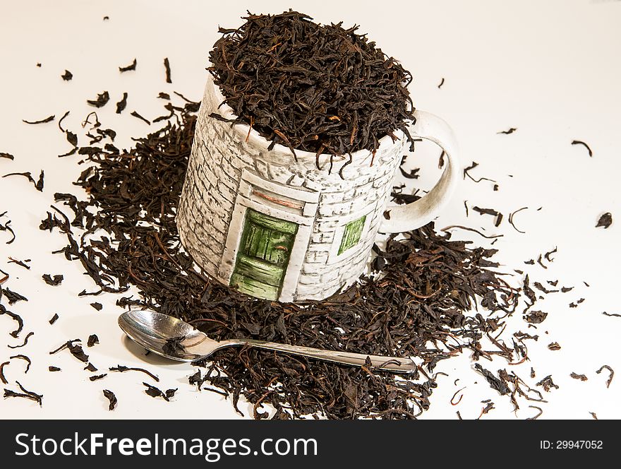 Tea cup full of tea leaves and a spoon. Tea cup full of tea leaves and a spoon