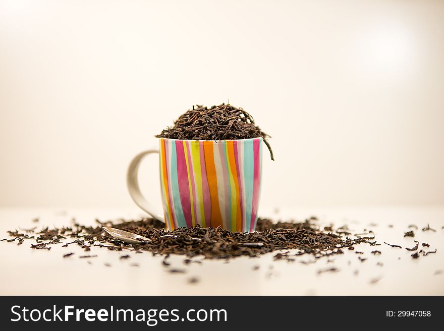 Tea cup full of tea leaves and a spoon. Tea cup full of tea leaves and a spoon