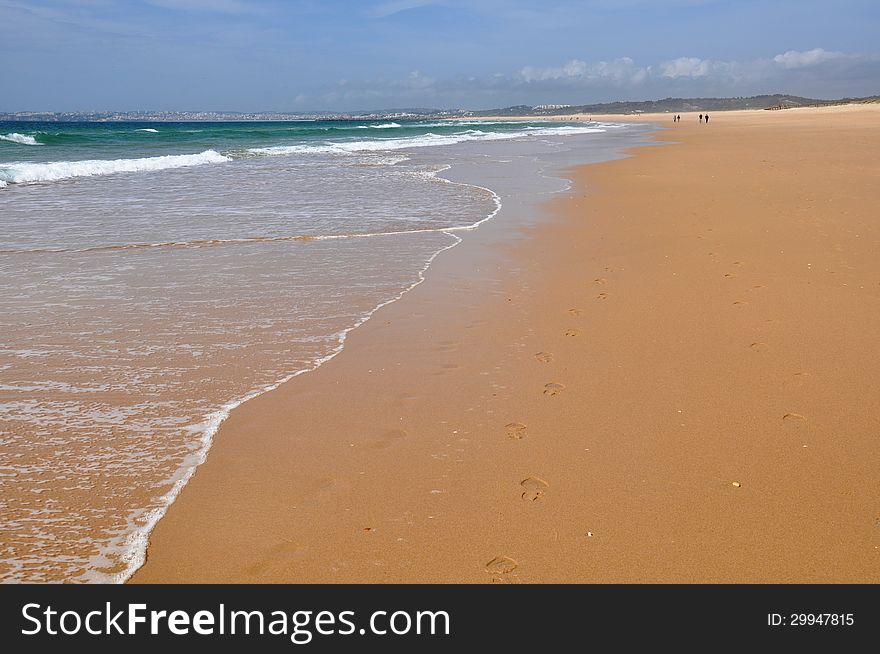 Image shows popular beach of Alvor, Algarve, Portugal, Europe. Some tourists on the left.