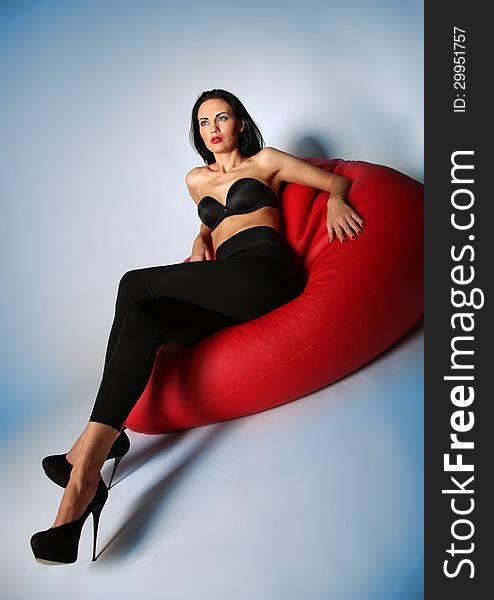 brunette Beauty sitting on a red armchair. This image has attached release. brunette Beauty sitting on a red armchair. This image has attached release.