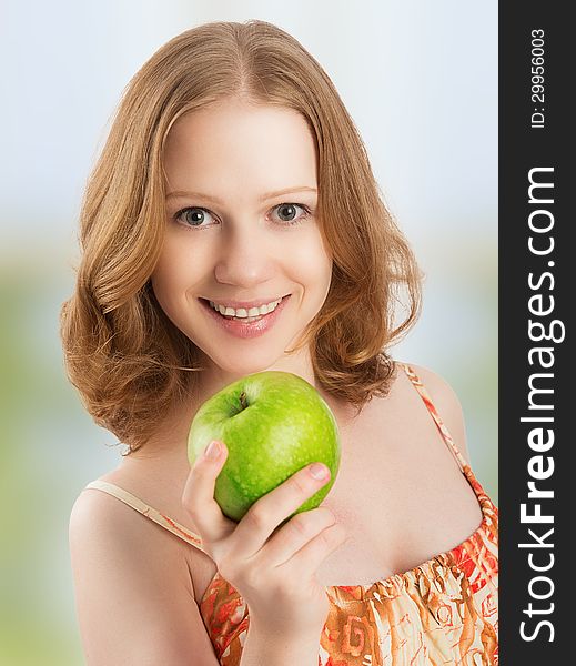 Young healthy woman eating fruit, green apple at home