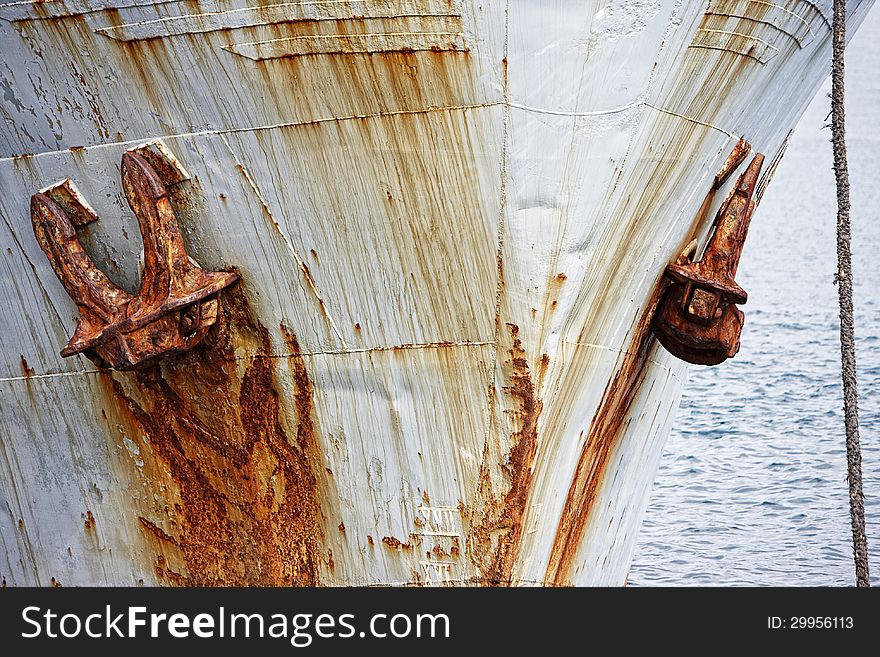 Front of an old rusty boat with anchor