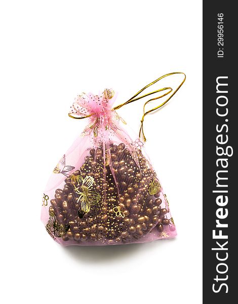 Yellow pearl in a pink transparent bag isolated over white. Yellow pearl in a pink transparent bag isolated over white