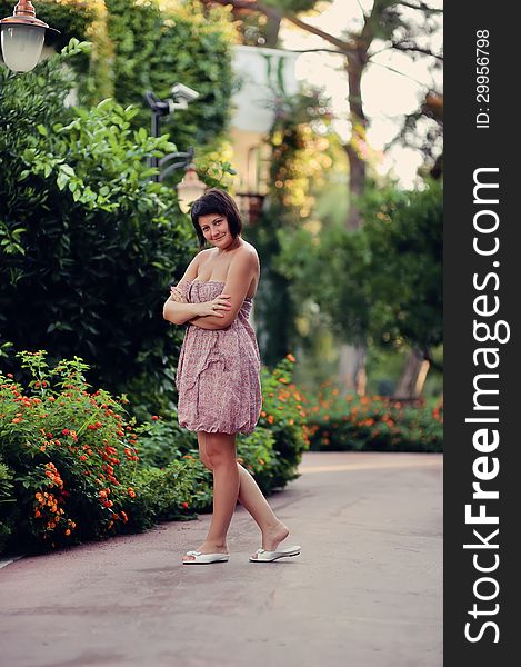 Summer day in the park beautiful young woman in color dress posing. Summer day in the park beautiful young woman in color dress posing