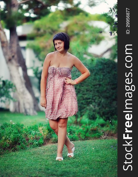 Summer day in the park beautiful young woman in color dress posing. Summer day in the park beautiful young woman in color dress posing