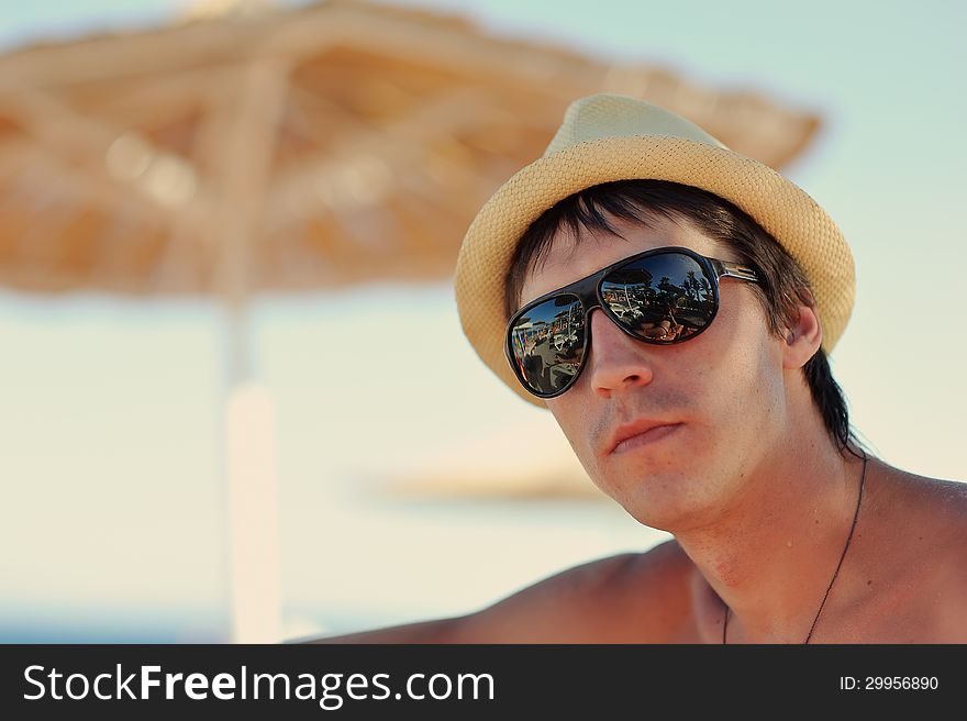 Portrait of a guy in a straw hat and black sunglasses. Portrait of a guy in a straw hat and black sunglasses