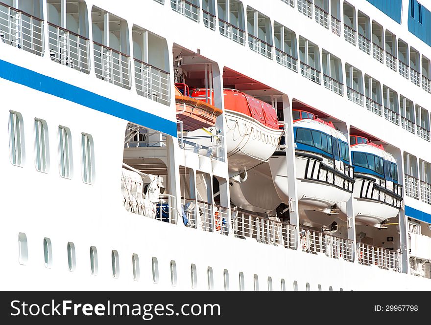 Sea travel background. Vacation on board the cruise liner - the portholes and lifeboats. View on luxury ocean liner. Seaside of the white passenger ship.