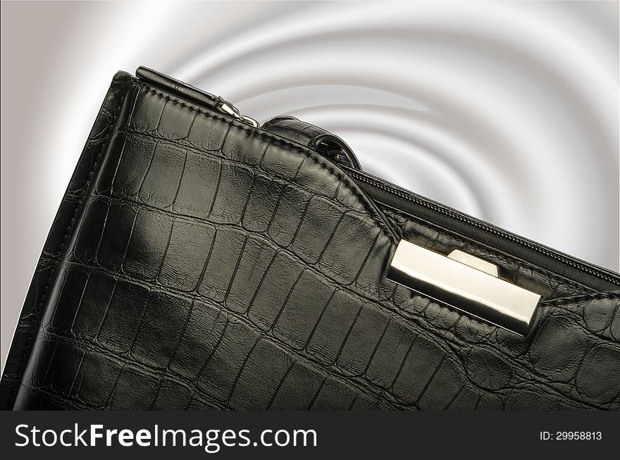 A black business handbag isolated on a graduated background