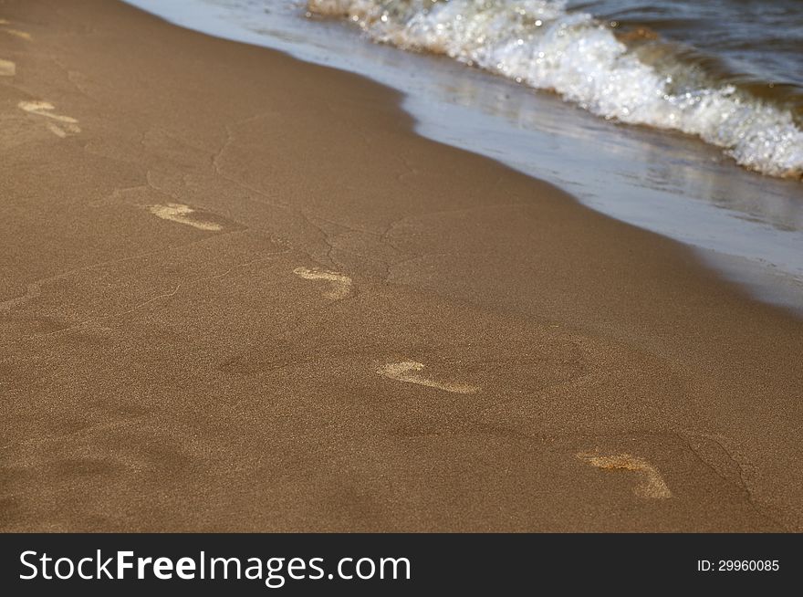 Footprints of bare feet along the shore of a sea. Footprints of bare feet along the shore of a sea