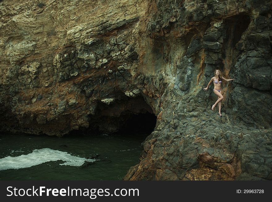 Swimsuit model posing in front of black lava field on at Palos Verdes, CA. Swimsuit model posing in front of black lava field on at Palos Verdes, CA