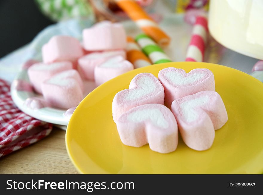 Pink marshmallow on yellow plate. Pink marshmallow on yellow plate