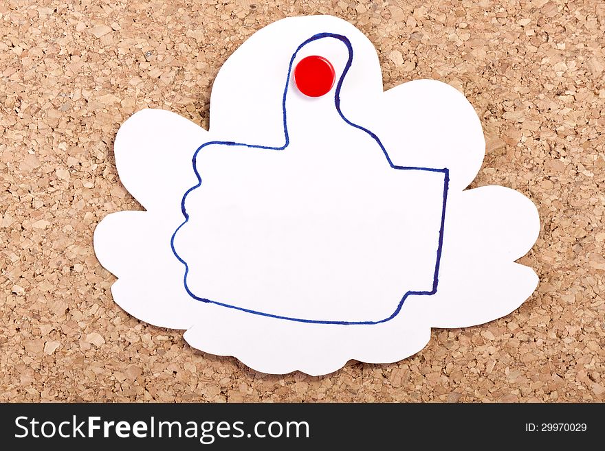 Cloud shape paper note with a like thumb drawing inside with a pen on a corkboard. Cloud shape paper note with a like thumb drawing inside with a pen on a corkboard.