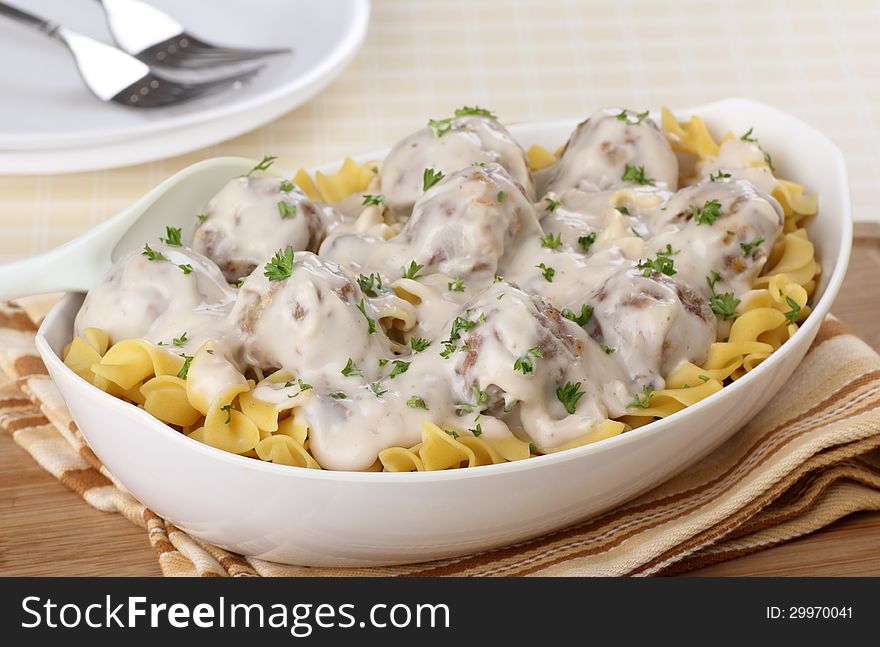 Meatballs with sauce on top of egg noodles in a bowl