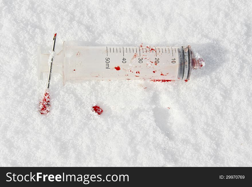 Bloody used syringe
