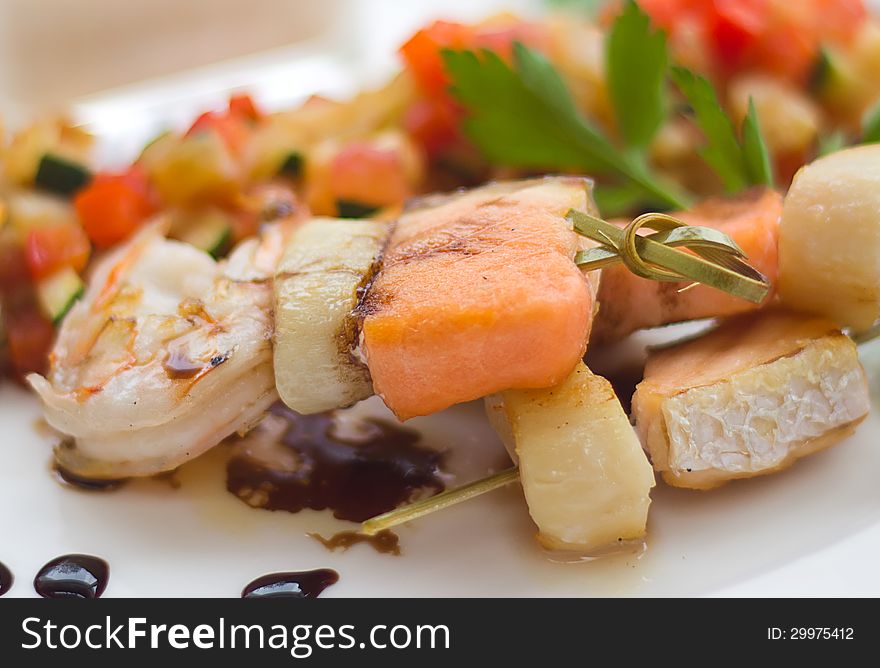 Closeup of grilled salmon and shrimps with vegetables.