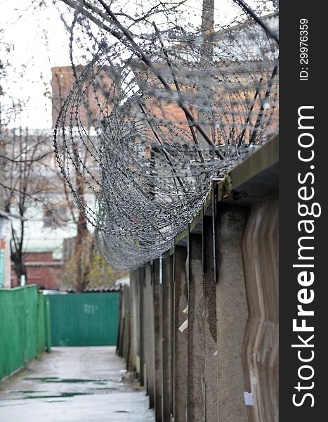 Concrete fence protected by barbed wire. Concrete fence protected by barbed wire
