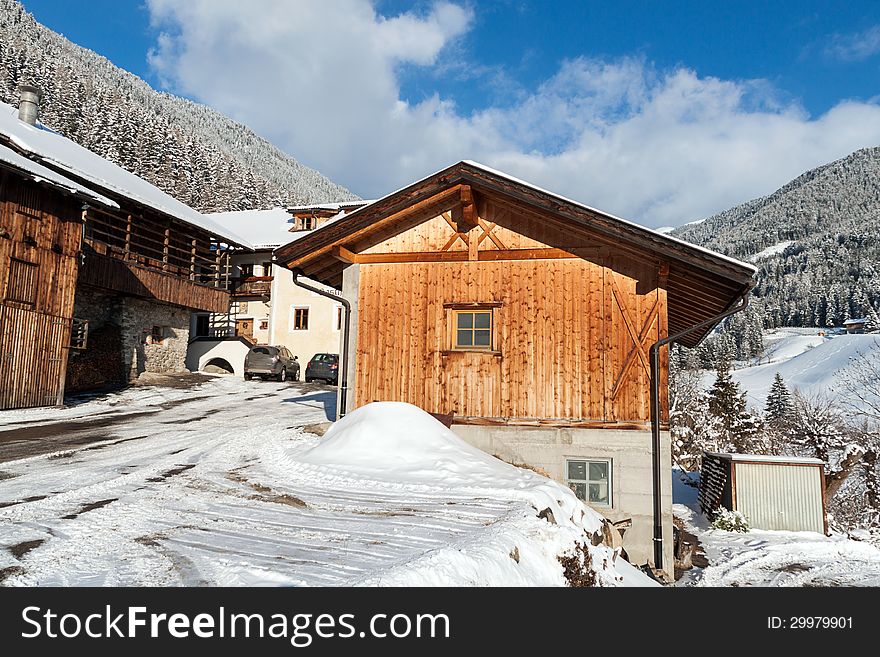 Wooden cottage near the pine forest, covered in snow