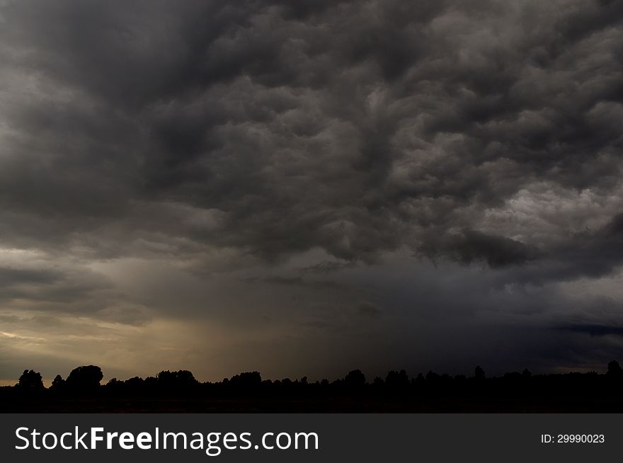 The photograph shows the sky covered with dark, heavy storm clouds. The photograph shows the sky covered with dark, heavy storm clouds.