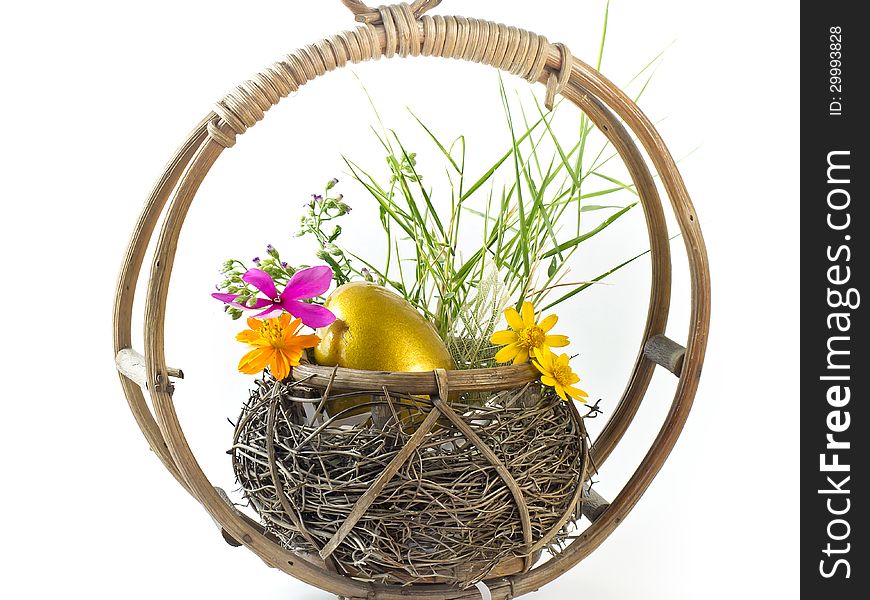 Golden Easter egg in the basket with flowers