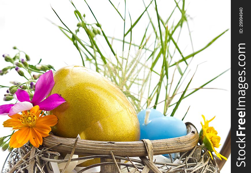 Golden Easter egg in the basket with flowers