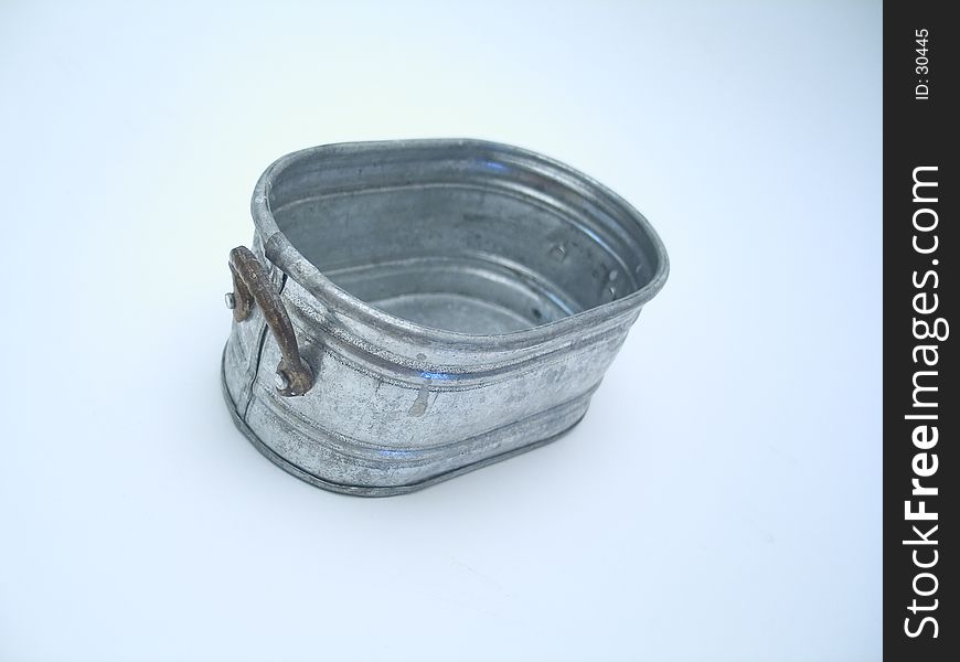 A miniature pail on a blue toned background. A miniature pail on a blue toned background.