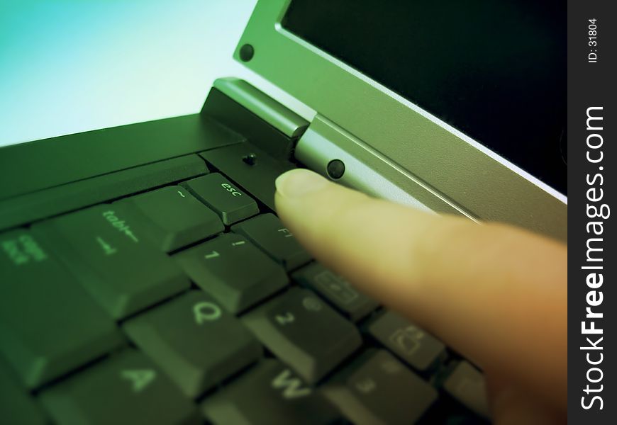 Finger about to press the escape key on a laptop. Focus on the esc. key. Finger about to press the escape key on a laptop. Focus on the esc. key.