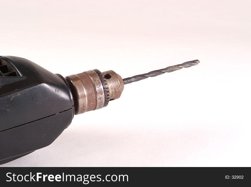 Detail of an electric drill showing the drill chuck and a bit. Photographed on a white background. Detail of an electric drill showing the drill chuck and a bit. Photographed on a white background