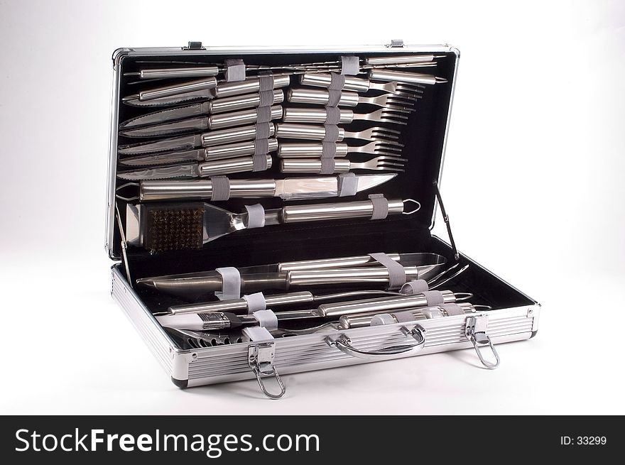 An aluminum case containing various Bar-B-Que tools made of stainless steel